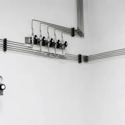 Wall-mounted point-of-use regulators connected through stainless-steel gas tubing