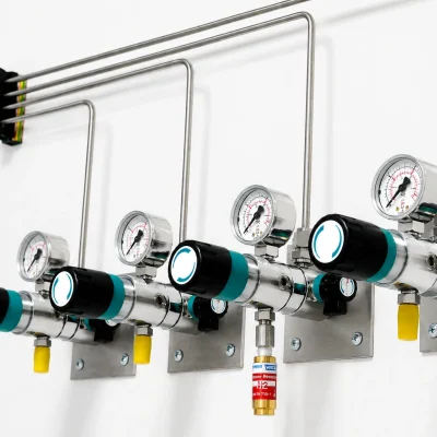 Wall-mounted point-of-use regulators connected through stainless-steel gas tubing