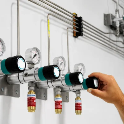 Operator adjusting a laboratory gas regulator fitted with a flashback arrestor