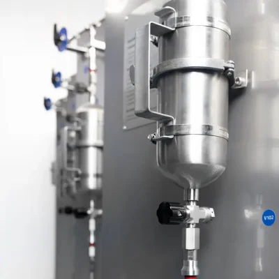 Side view of a stainless-steel sampling cylinder on a process panel