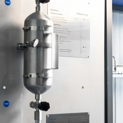 Stainless-steel sampling cylinder installed beside operating instructions