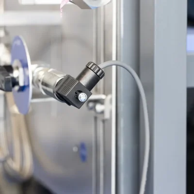 Close-up of a sampling-system connector mounted beside the cylinder