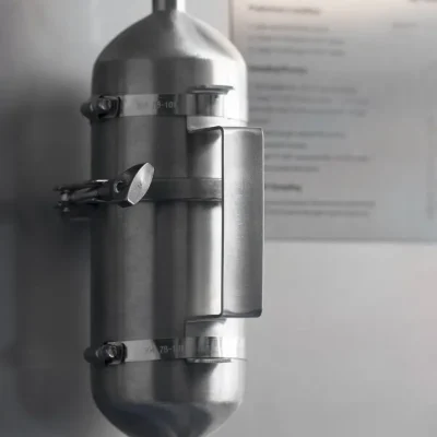 Front view of a wall-mounted stainless-steel sampling cylinder