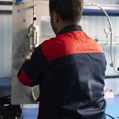 Technician operating a wall-mounted closed-loop sampling cylinder system